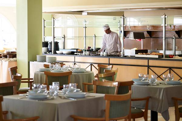 Restaurant im Mitsis Family Village Beach Hotel mit Chefkoch hinter der Theke.