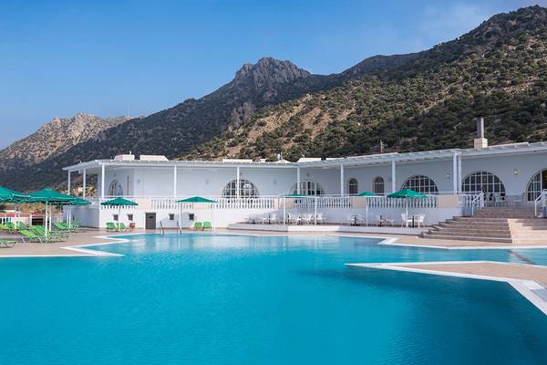 Außenpool des Mitsis Family Village Beach Hotels mit grünen Sonnenschirmen und Liegestühlen.