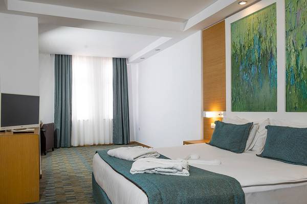 Hotelzimmer im Ladonia Hotels Adakule mit Bett, Fernseher und Dekor.