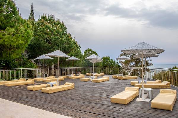 Hotelterrasse mit Sonnenliegen und Sonnenhüten an der Küste