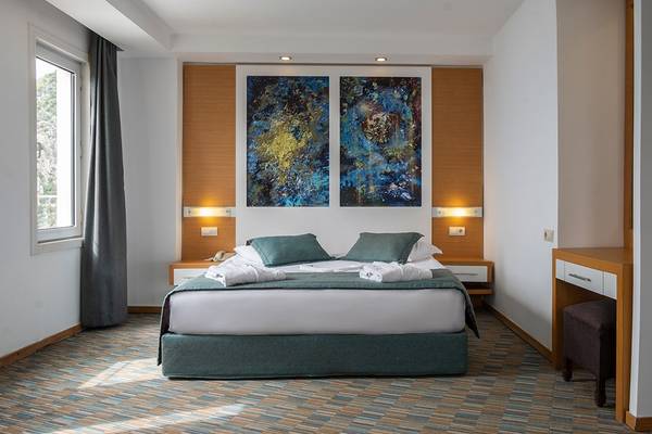 Schlafzimmer im Ladonia Hotels Adakule mit Doppelbett, Kunstwerken und Fenstern