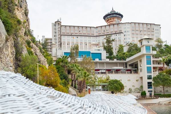 Außenansicht des Ladonia Hotels Adakule von der Seite, umgeben von Bäumen und Pflanzen.