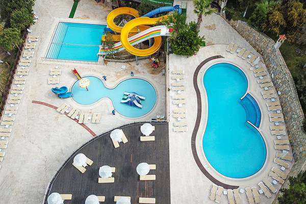 Luftaufnahme der Poolanlage im Ladonia Hotels Adakule mit Rutschen und Liegebereichen.