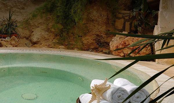 Jacuzzi im Freien mit Pflanzen im Hintergrund im Coral Beach Hotel & Resorts