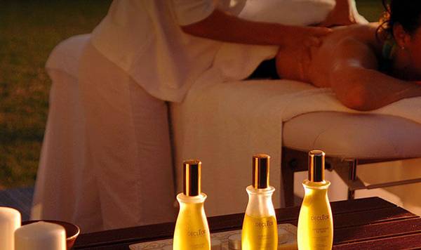 Frau genießt Massage im Freien im Coral Beach Hotel & Resorts
