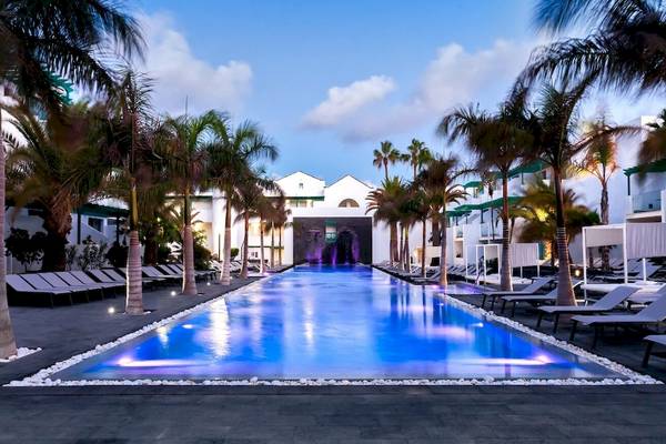 Außenpoolbereich des Barceló Teguise Beach Adults Only Hotel mit Lounge-Stühlen und Palmen