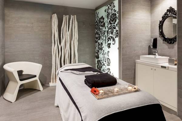 Spa-Behandlungsraum im Barceló Teguise Beach Adults Only Hotel mit Liege, Stuhl und Waschbecken.