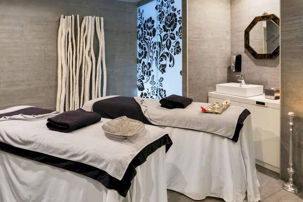 Spa-Behandlungsraum im Barceló Teguise Beach Adults Only Hotel mit zwei Massagetischen und einem Waschbecken.