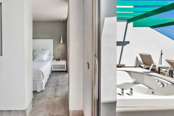 Innenansicht des Barceló Teguise Beach Adults Only Hotels mit einem Bett, Fernseher und einem kleinen Tisch