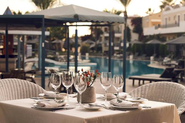 Ein Tisch im Freien des Pelagos Suites Hotel & Spa mit einer Aussicht auf den Pool.