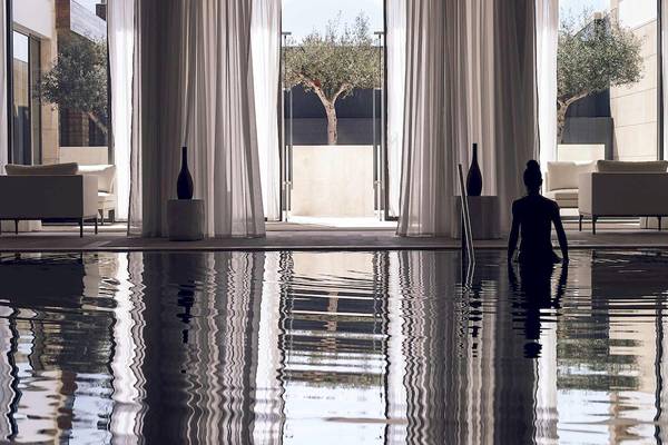 Eine Frau im Pool im Pelagos Suites Hotel & Spa