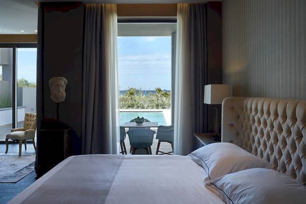 Schlafzimmer im Pelagos Suites Hotel & Spa mit Blick auf die Terrasse und das Meer