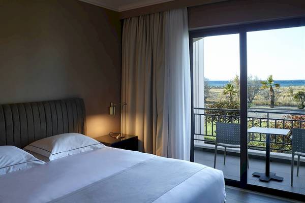 Schlafzimmer im Pelagos Suites Hotel mit Balkon und Meerblick.