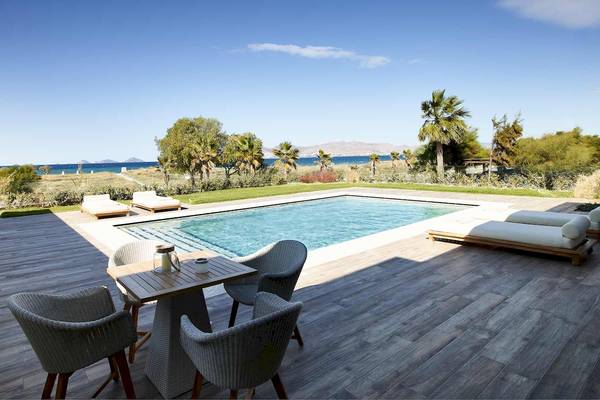 Pool auf Holzterrasse im Pelagos Suites Hotel & Spa mit Blick auf das Meer.