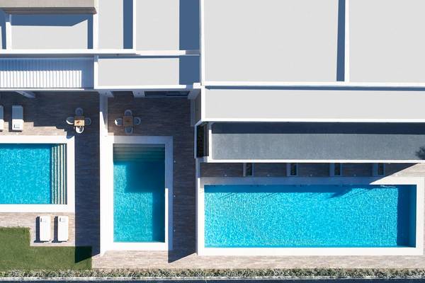 Luftaufnahme des Pelagos Suites Hotel & Spa mit mehreren Pools im Freien.