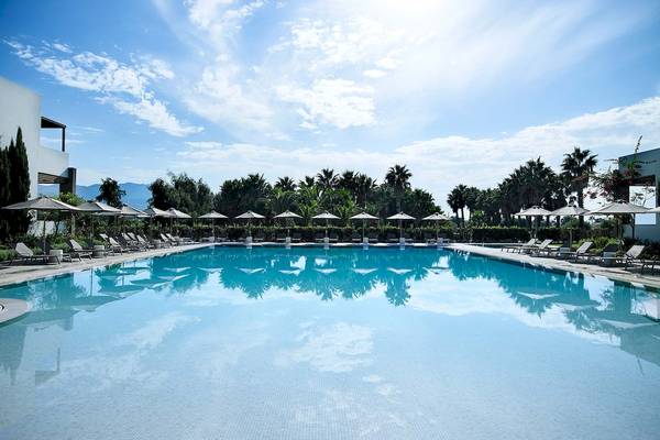 Außenpool mit Sonnenliegen und Sonnenschirmen im Pelagos Suites Hotel & Spa