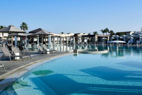 Außenpool des Pelagos Suites Hotel & Spa mit Liegestühlen und Sonnenschirmen