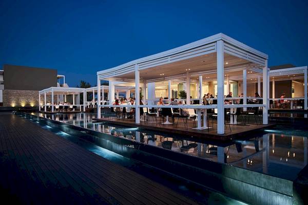 Abendessen im Restaurant des Pelagos Suites Hotel & Spa mit Gästen, die draußen sitzen.