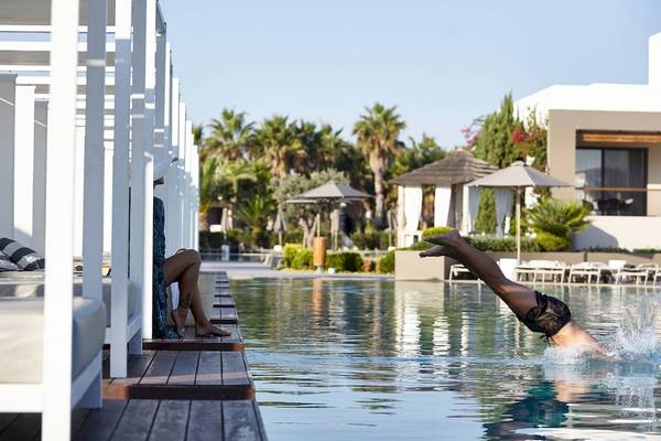 Mann springt in den Pool am Pelagos Suites Hotel & Spa.