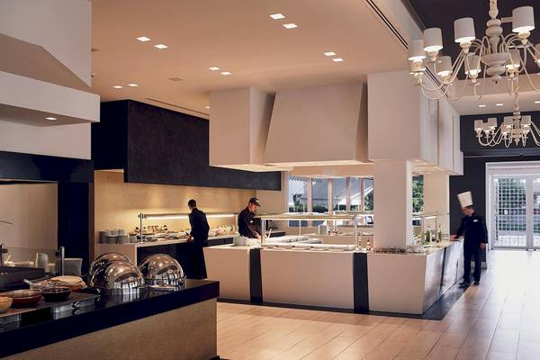 Innenansicht des Restaurants im Pelagos Suites Hotel mit Buffet, Mitarbeitern und Dekor.