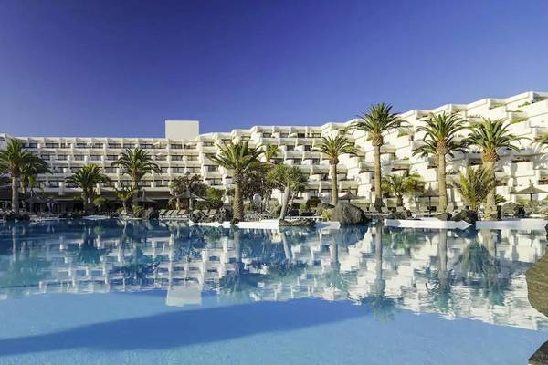Außenbereich des Melia Salinas Hotels mit großem Pool und weißen Gebäuden.