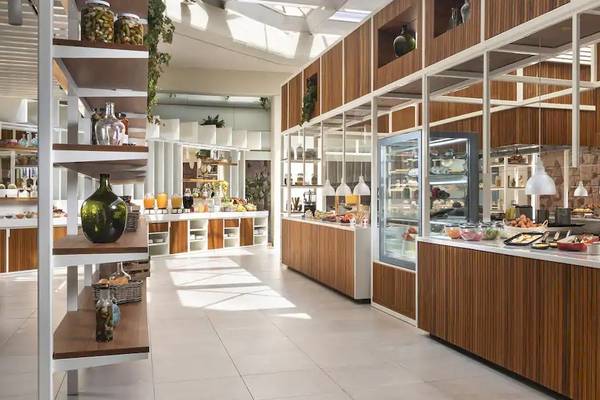 Frühstücksbereich des Melia Salinas Hotels mit Frühstücksbuffet und Holzmöbeln.