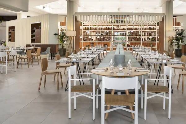 Innenansicht des Restaurants im Melia Salinas Hotel mit leeren Tischen, Stühlen und Regalen.