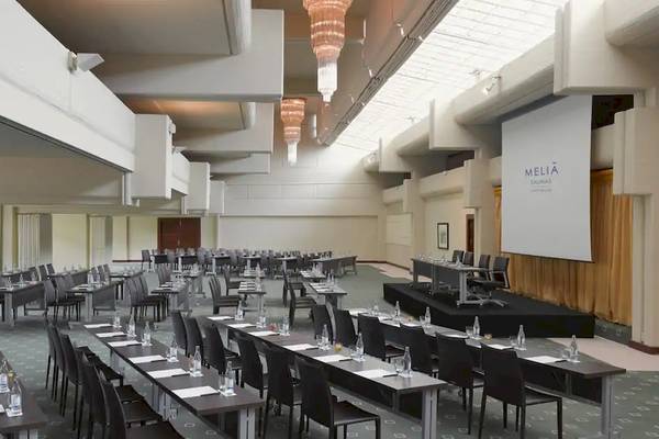 Konferenzsaal im Melia Salinas Hotel mit vielen Tischen, Stühlen und einer Leinwand