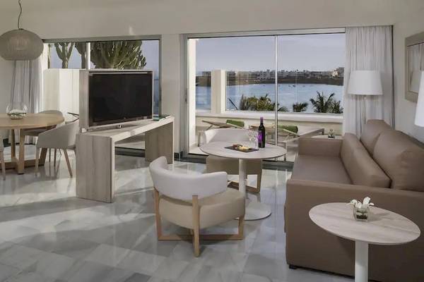 Wohnzimmer des Melia Salinas Hotels mit moderner Einrichtung und Meerblick.