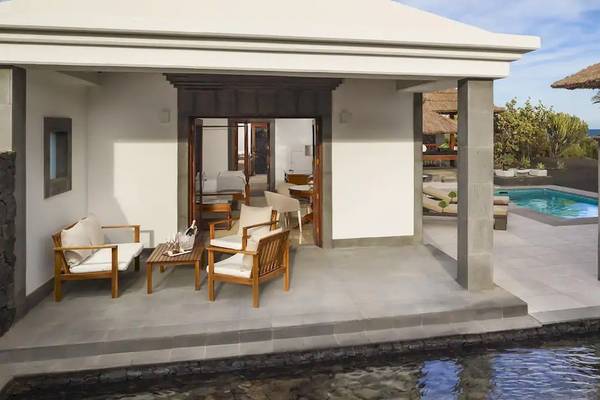 Außenbereich der Melia Salinas Pool Suite mit Terrasse, Möbeln und Pool.