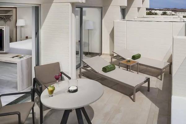 Aussicht von der Balkon des Melia Salinas Hotels mit Lounge-Sesseln, Tisch und Getränken.