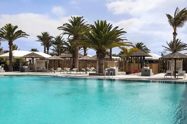 Poolbereich des Melia Salinas Hotels mit Loungestühlen und Palmen