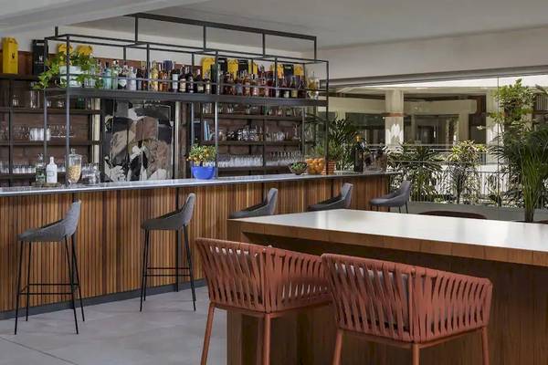 Innenansicht der Bar im Melia Salinas Hotel mit Barhockern, Holztheke und Regalen voller Flaschen.