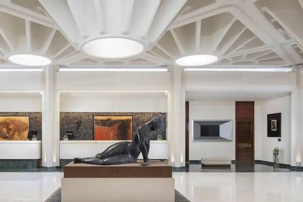 Empfangsbereich des Melia Salinas Hotels mit einer Skulptur im Vordergrund und Gemälden an den Wänden.