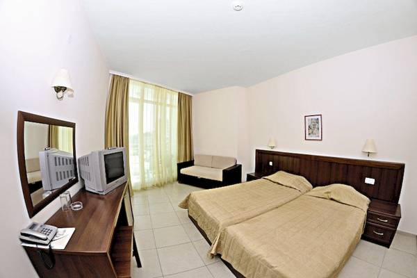 Doppelzimmer im Glarus Hotel mit zwei Betten, Couch, Fernseher, Spiegel und Schreibtisch.