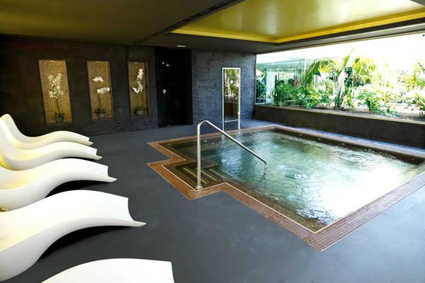 Innenpool im Riu Gran Canaria Hotel mit weißen Liegestühlen und Pflanzen im Hintergrund