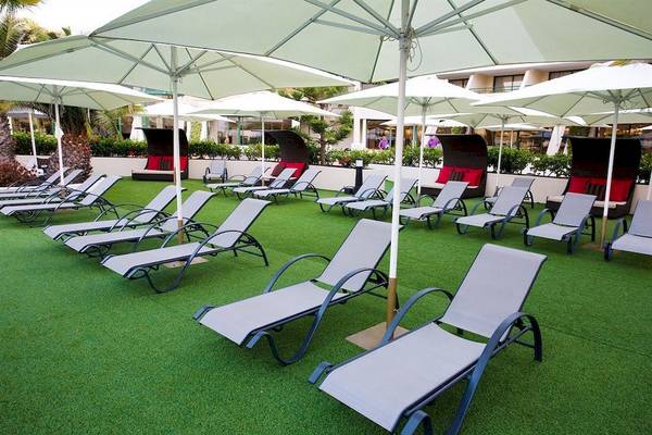 Lounge-Bereich im Dreams Lanzarote Playa Dorada Resort & Spa mit vielen Liegestühlen und Sonnenschirmen.