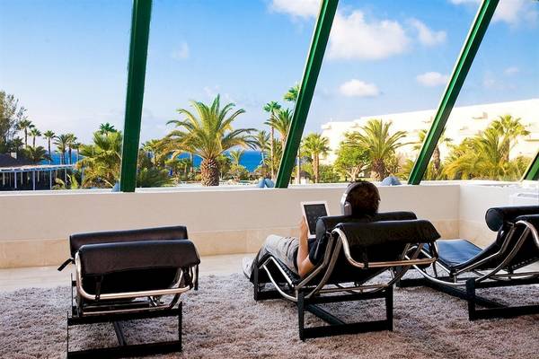Person entspannt sich auf einem Liegestuhl mit Blick auf den Ozean