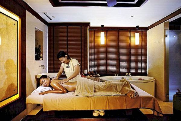 Spa-Behandlung im Centara Grand Beach Resort & Villas Krabi mit einer Frau, die eine Massage genießt.