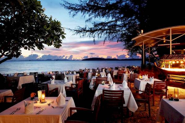 Abendessen am Strand im Centara Grand Beach Resort & Villas Krabi mit Blick auf das Meer und die bunte Abenddämmerung.