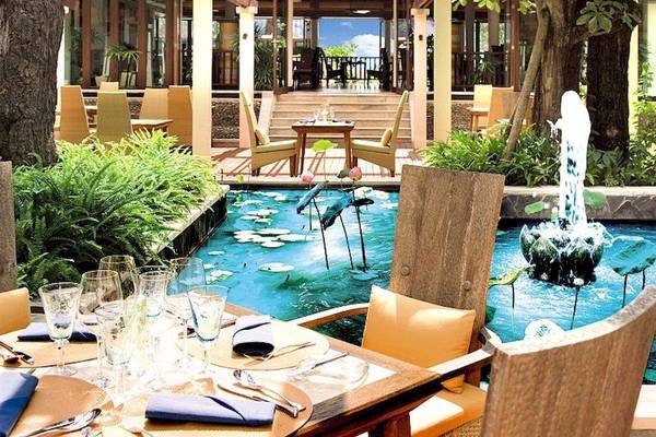 Restaurantterrasse des Centara Grand Beach Resort & Villas Krabi mit Wasserbrunnen und Tisch.