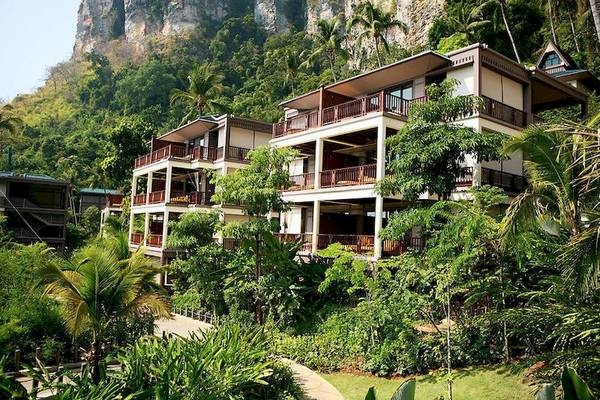 Luftaufnahme des Centara Grand Beach Resort & Villas Krabi mit mehreren Stockwerken und Balkonen, umgeben von Bäumen und Pflanzen.