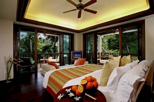 Luxuriöses Zimmer im Centara Grand Beach Resort & Villas Krabi mit Balkon, Fernseher und tropischen Früchten.