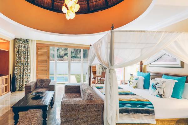 Innenansicht der Suite im Iberostar Grand Paraiso mit Bett, Fernseher und Möbeln.