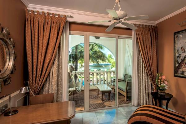 Hotelzimmer im Iberostar Grand Paraiso mit großer Glastür und Balkonansicht.