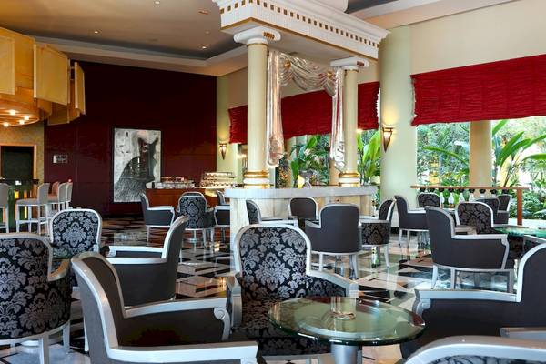 Hotellobby des Iberostar Grand Paraiso mit eleganten Möbeln und einem großen Wandbild.