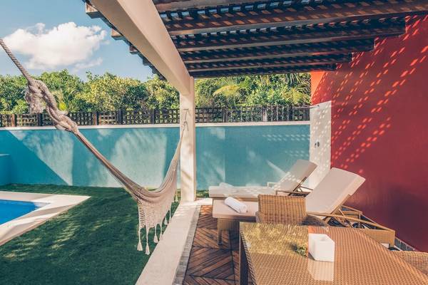 Poolbereich im Iberostar Grand Paraiso Hotel mit Hängematte und Liegestühlen.