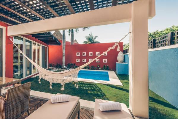Außenbereich des Iberostar Grand Paraiso mit Pool, Hängematte und Sitzmöbeln.