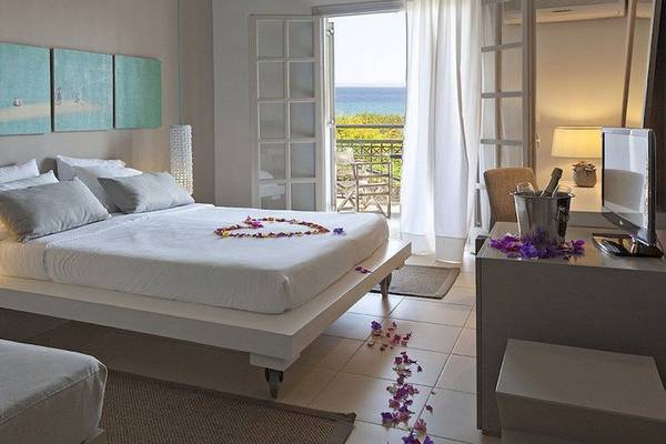 Schlafzimmer im The Bay Hotel & Suites mit Meerblick, Bett mit Blumendekor, Balkon und Meersicht