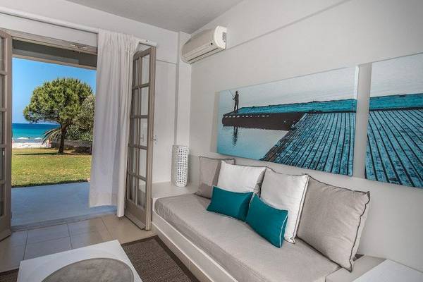 Wohnzimmer mit Meerblick im Bay Hotel & Suites, mit offenem Balkon und großer Fensterfront.